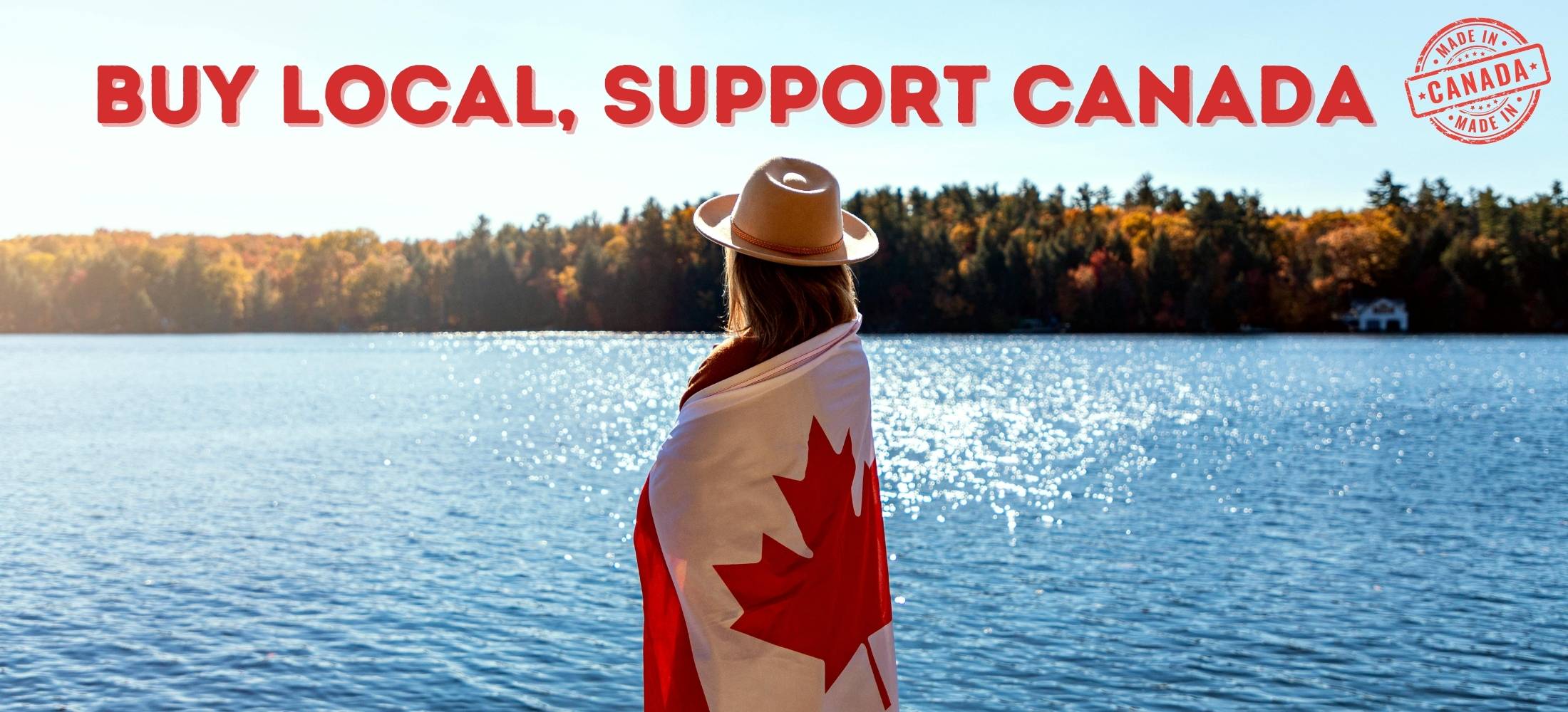 Woman wearing a Canadian flag looks out at the Canadian wilderness